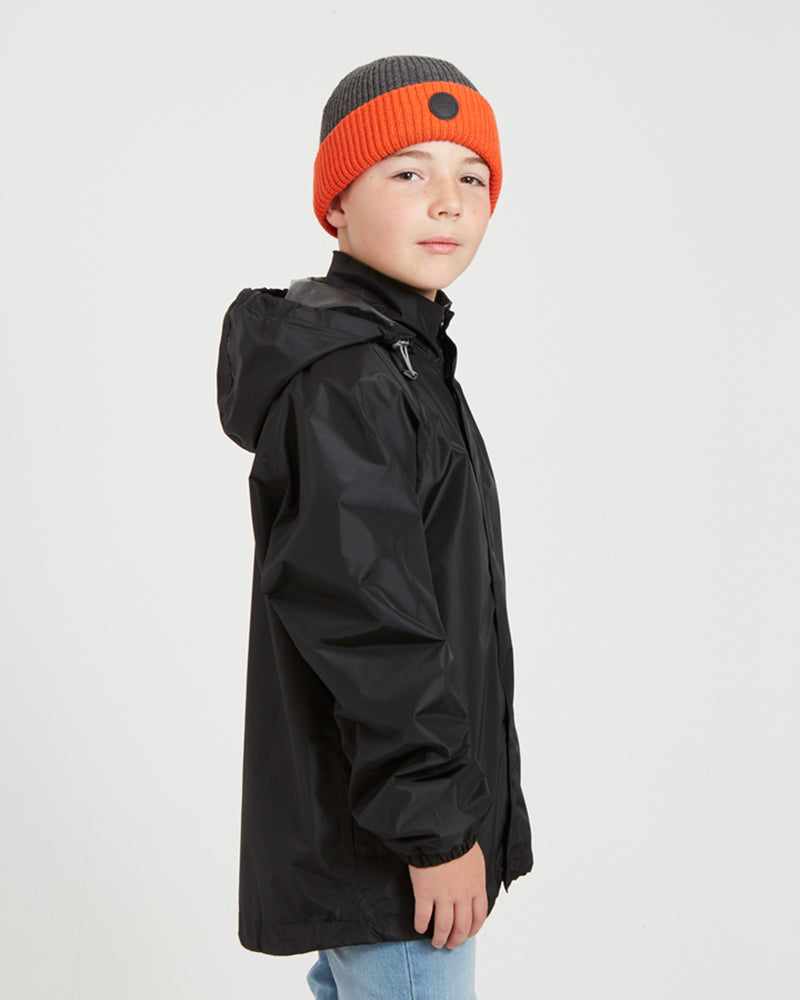 Side view of the XTM Kids Stash 2L packable rain jacket in Black, hood down