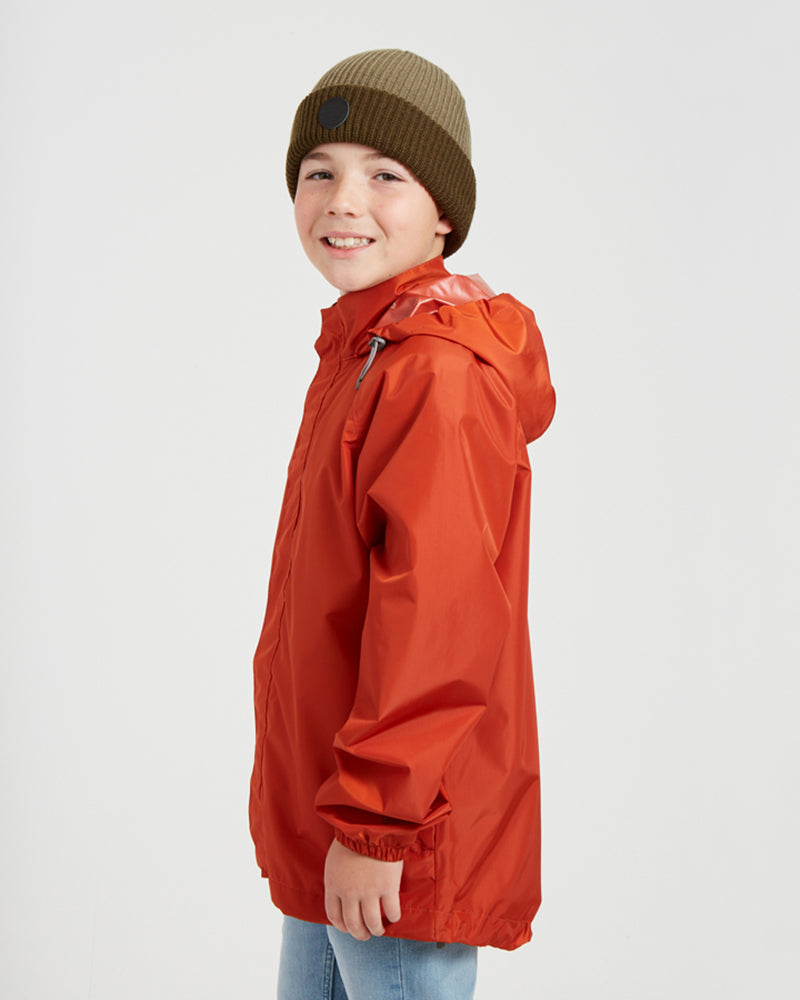 Side view of the XTM Kids Stash 2L rain jacket in Burnt Orange, hood down