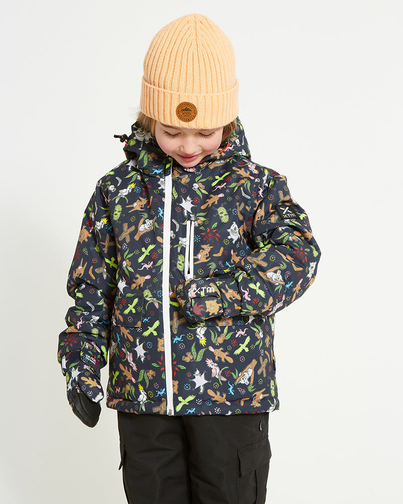 Child in the Woodland Navy XTM Kids Yama Snow Jacket looking down, showing the animal and leaf print
