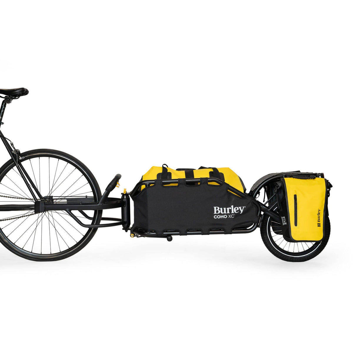 Burley Coho XC hitched to a bike, carrying a yellow duffel and yellow panniers on the rear rack