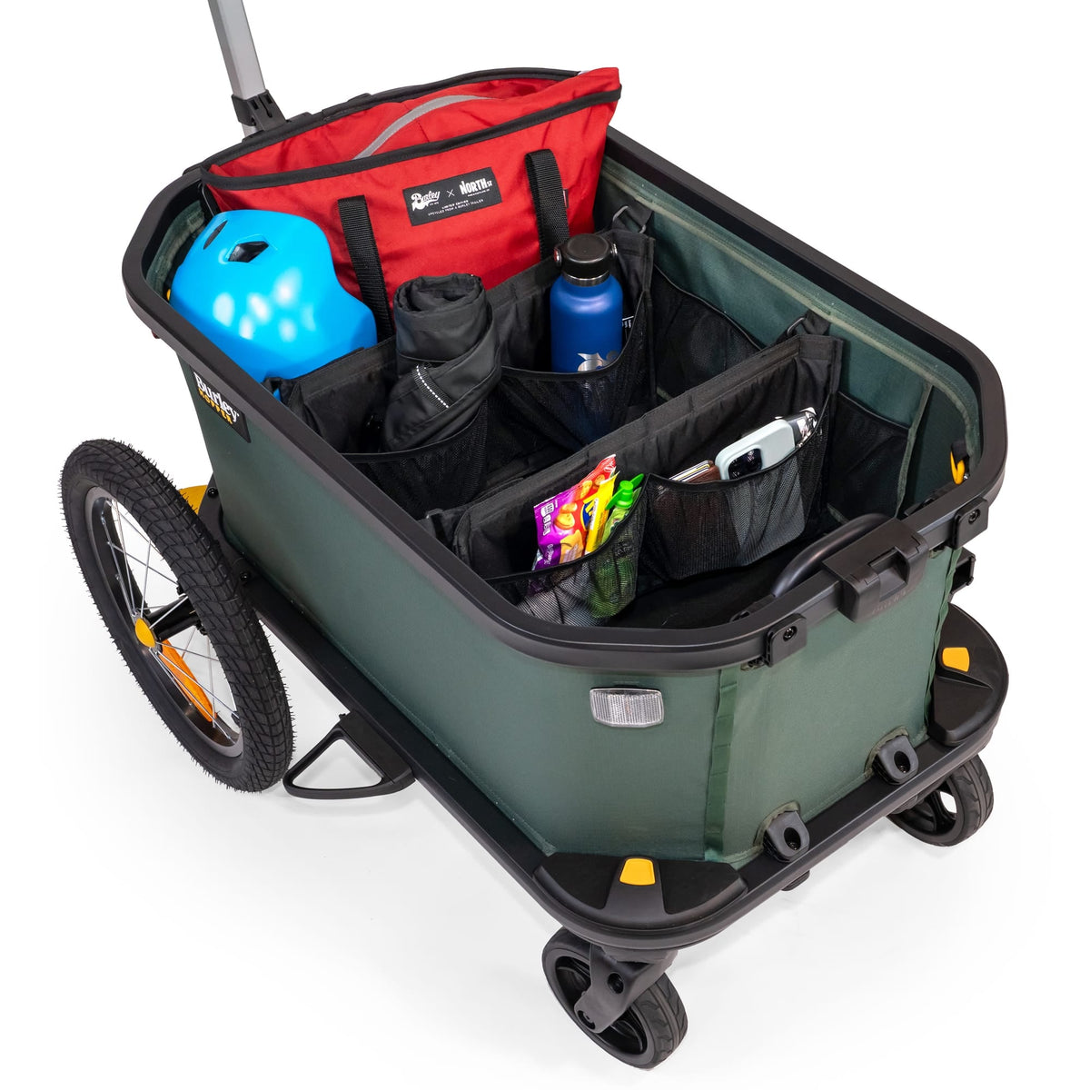 Burley Hopper cargo area split by the dividers, holding a red bag, blue helmet, drink bottle and snacks