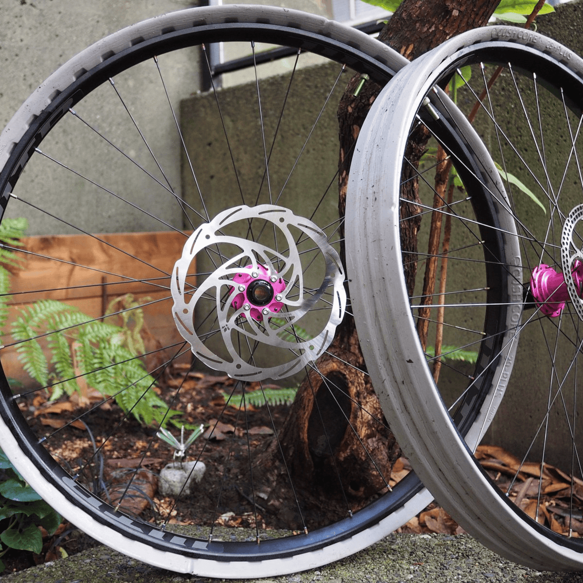 CushCore inserts fitted around two mountain bike rims leaning in a garden