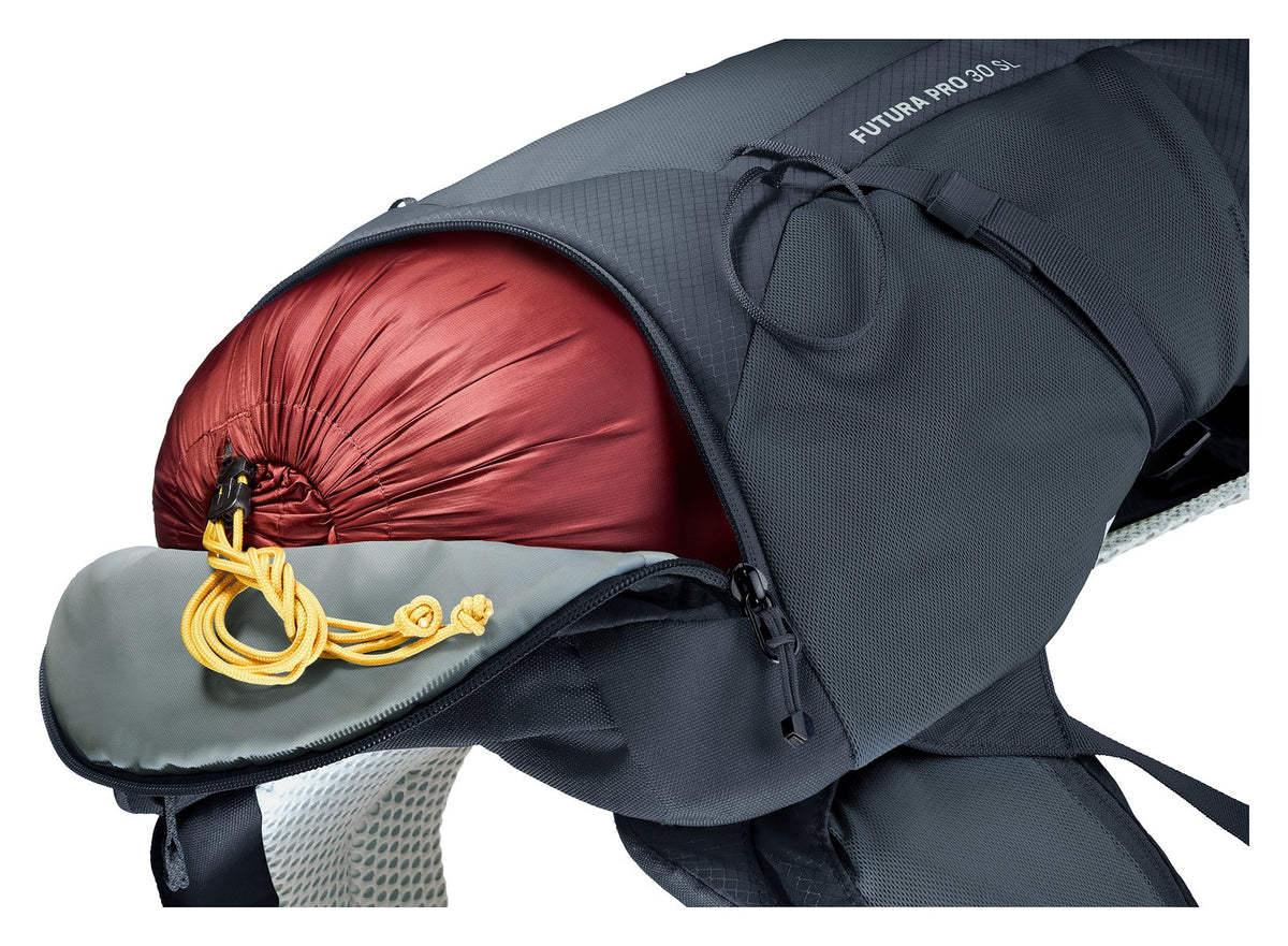Separate bottom compartment of the Deuter Futura Pro 30 SL holding a red sleeping bag