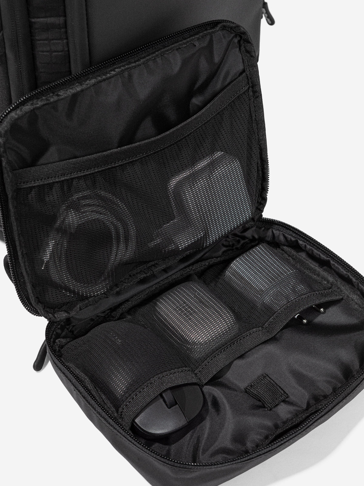 Inside the Orca Casual Backpack: mesh zip pockets holding a mouse and cables
