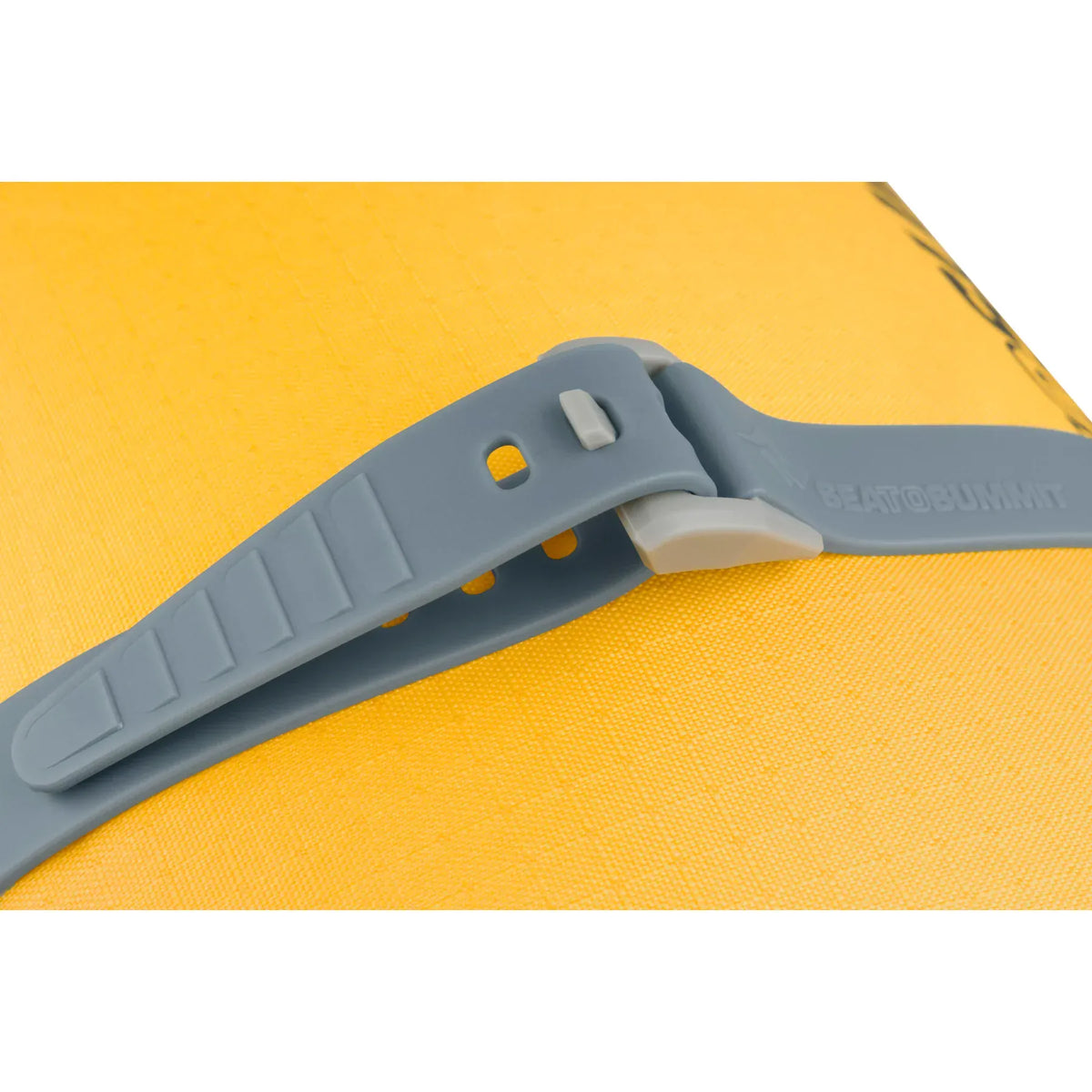 Grey Stretch-Loc buckle and ridged tail lying on yellow dry bag fabric
