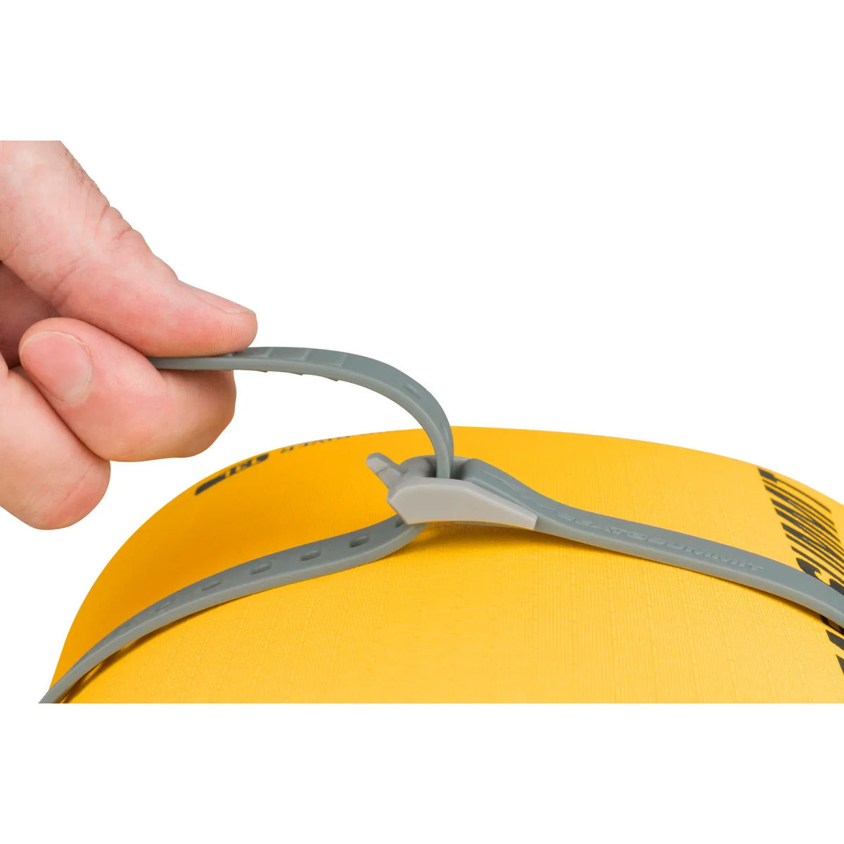 Hand pulling a grey Stretch-Loc strap tight over a yellow dry bag