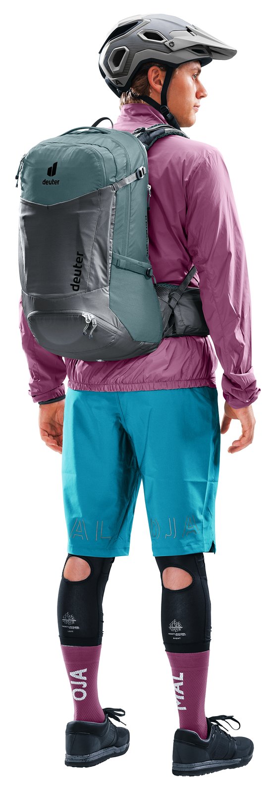 Mountain biker in helmet and knee pads wearing the Deuter Trans Alpine Pro 28