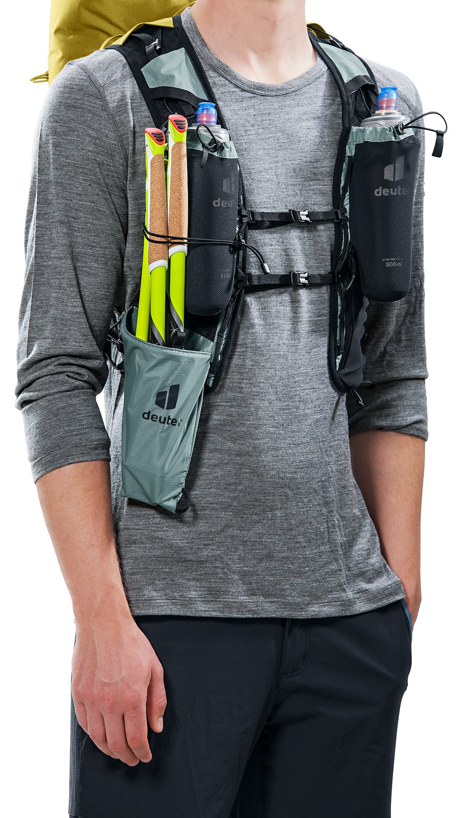 Man wearing the Deuter Vertrail 16 vest with poles in the shoulder holster