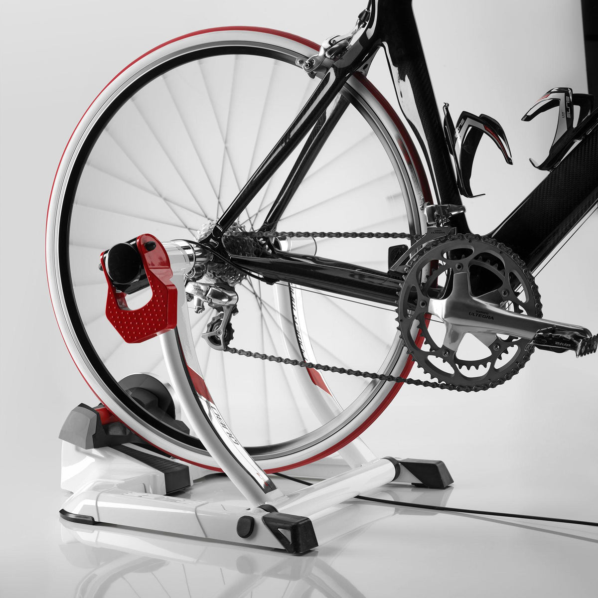 Road bike mounted on the Elite Qubo Power Mag Smart B+ trainer, drivetrain and roller in view