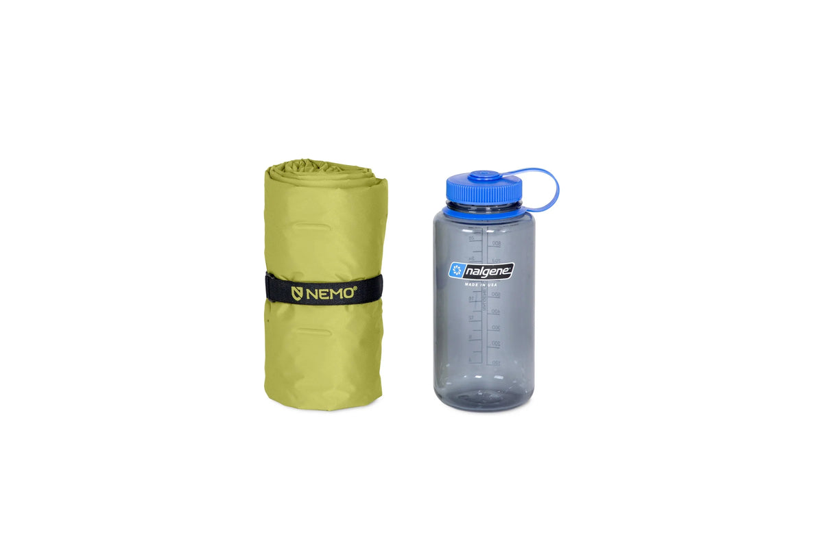 Nemo Eclipse All-Season Regular Wide rolled and strapped beside a drink bottle