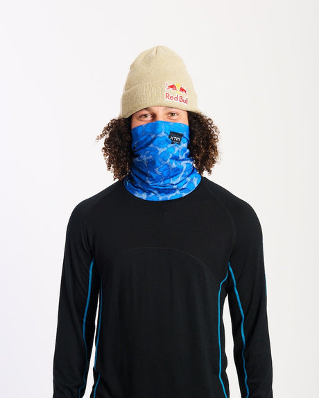 Model wearing the XTM Valentino neck tube in blue Snow Leopard print pulled up over the nose, front view
