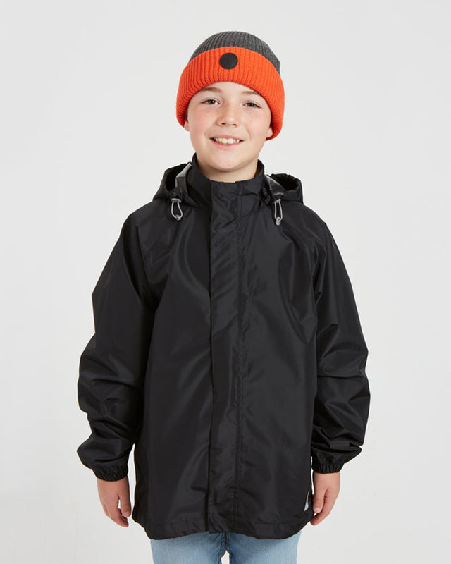 Boy wearing the XTM Kids Stash 2L rain jacket in Black, front view, zipped with hood rolled away