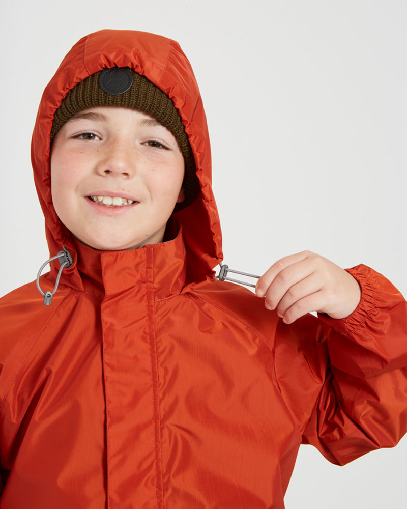 Close-up of the elastic hood on the XTM Kids Stash 2L rain jacket in Burnt Orange, toggle in hand