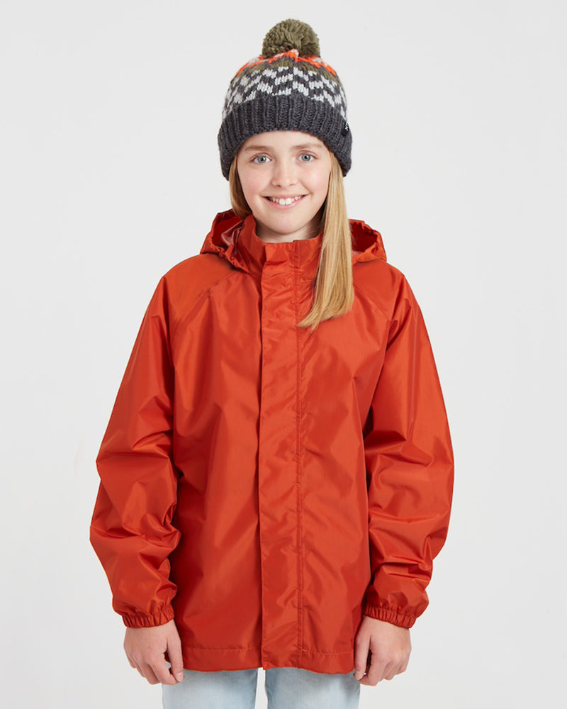 Girl in the XTM Kids Stash 2L rain jacket in Burnt Orange, front view with hood toggles