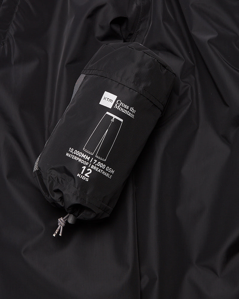 XTM Kids Stash 2L rain pant packed down small, label showing 10,000 mm waterproof rating