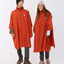 Man and woman wearing Burnt Orange XTM Stash 2L ponchos over long sleeve tops