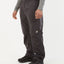 Model wearing XTM Takayna rain pant in Granite dark charcoal, front view with elastic waist, worn over boots
