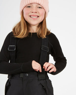 XTM Kids Pluto II Snow Pant in Black, child adjusting a brace at the waist