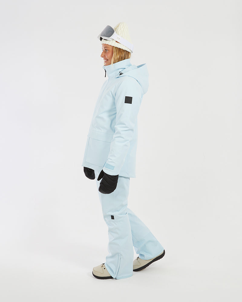 Woman walking in the Sky Blue XTM Elevation II ski jacket, side profile