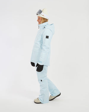 Woman walking in the Sky Blue XTM Elevation II ski jacket, side profile