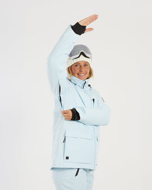 Woman raising her arm in the Sky Blue XTM Elevation II, showing the underarm and thumb-hole cuffs