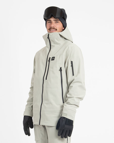 XTM Paradigm men's ski jacket in Stone Grey, three-quarter front view with the collar zipped up