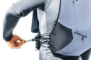 Runner pulling the elastic compression drawcord on the Deuter Ascender 7 shoulder strap