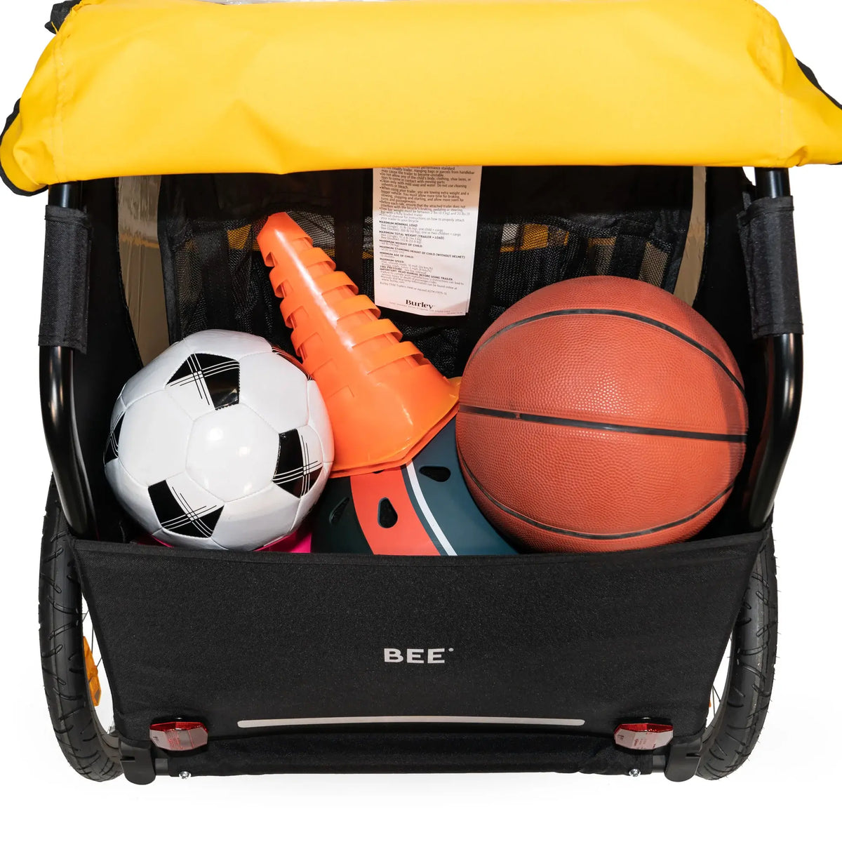Burley Bee Double rear cargo area holding a soccer ball, a basketball and a cone