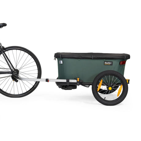 Burley Hopper hitched behind a bicycle as a cargo trailer, side view with the black cover closed