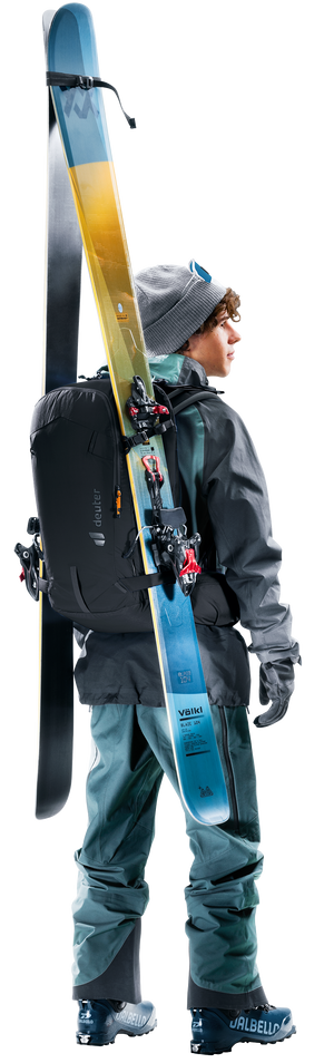 Skier wearing the Deuter Freerider 30 with skis strapped vertically at the side