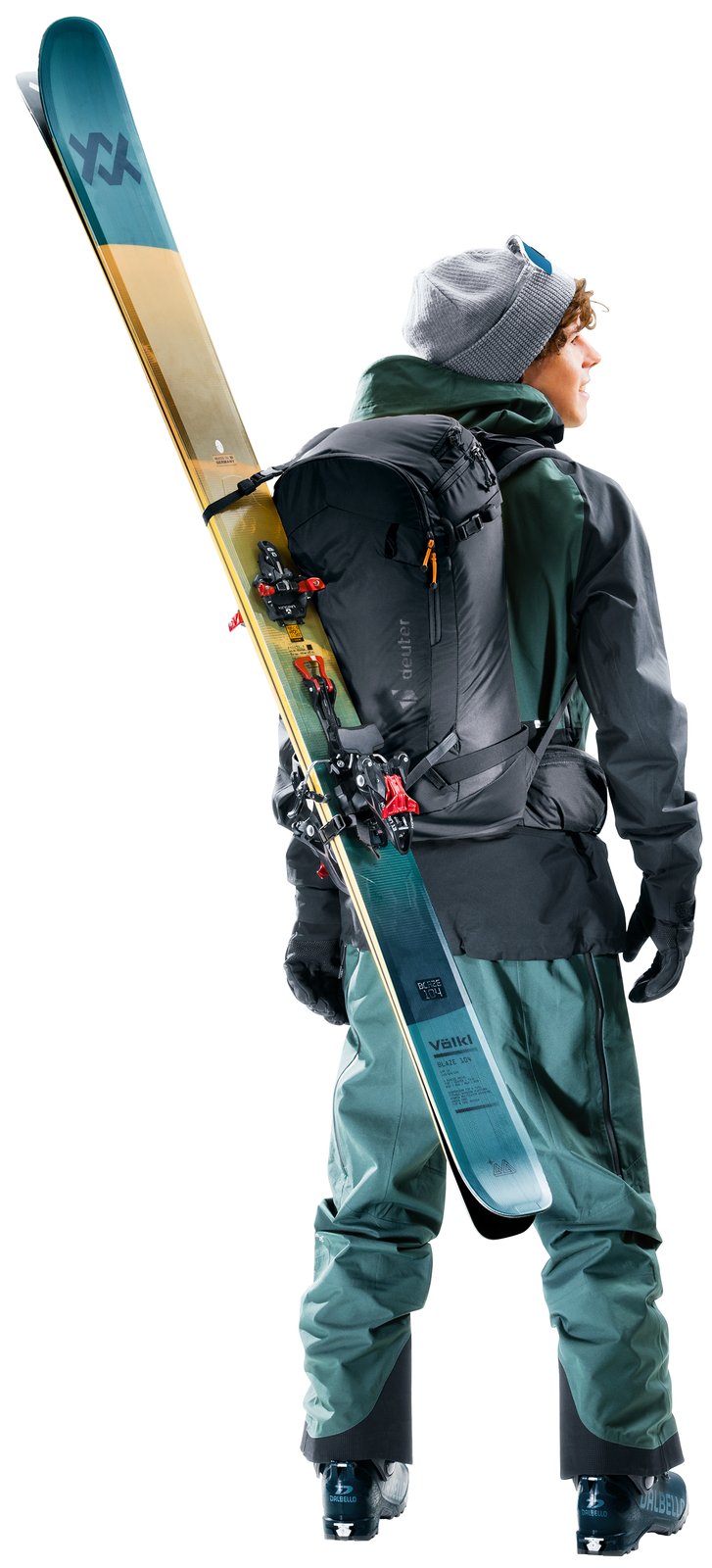 Skier wearing the Deuter Freerider Pro 32+10 with skis carried diagonally