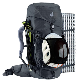 Deuter Guide 32+6 SL with a helmet in the mesh holder, folded poles on the side and a foam mat strapped on
