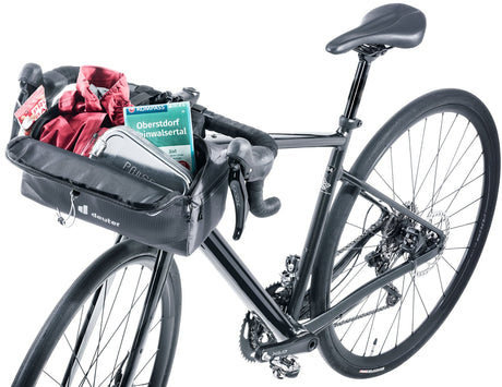 Deuter Mondego HB 8 mounted on a gravel bike's drop bars, open and packed with a jacket and map