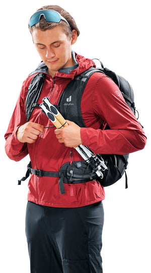 Hiker sliding folded poles into the quick-release holders on the Deuter Speed Lite Pro 25 straps