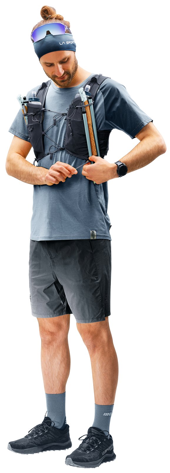 Deuter Traick 5 worn by a runner with folded poles in the front pockets, fastening the sternum strap