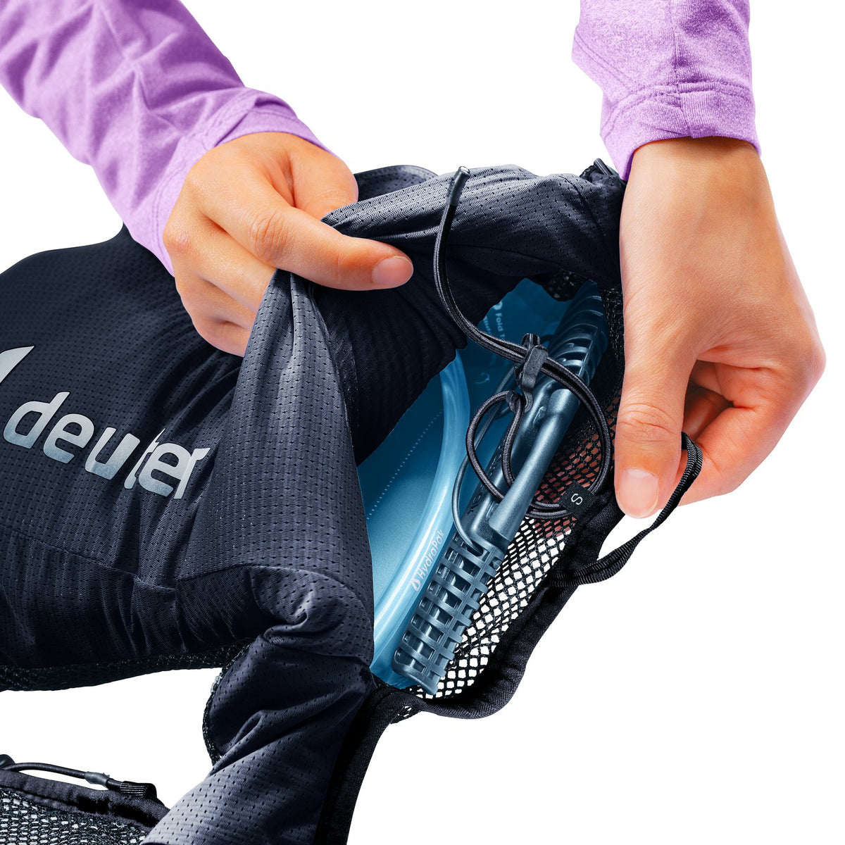 Hands pulling a hydration bladder from the rear compartment of the Deuter Traick 5 SL