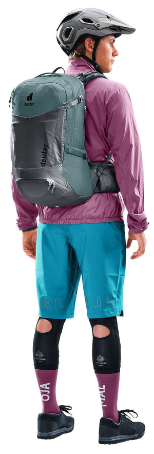 Mountain biker in helmet and knee pads wearing the Deuter Trans Alpine Pro 28