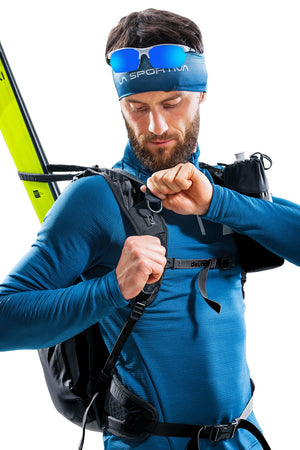 Ski tourer adjusting the sternum strap on the Deuter Updays 20 with skis on the pack