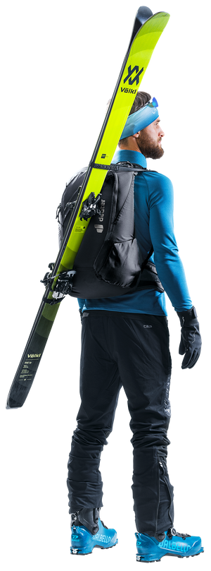 Ski tourer wearing the Deuter Updays 26 with skis carried diagonally