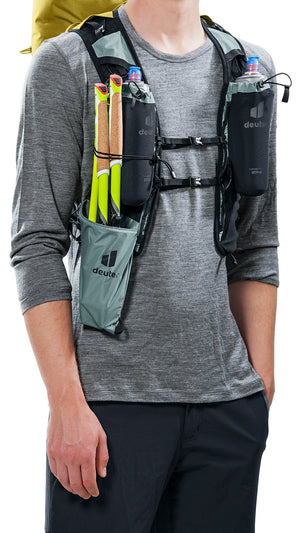 Man wearing the Deuter Vertrail 16 vest with poles in the shoulder holster
